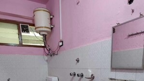 A bathroom with a toilet, sink, and shower.