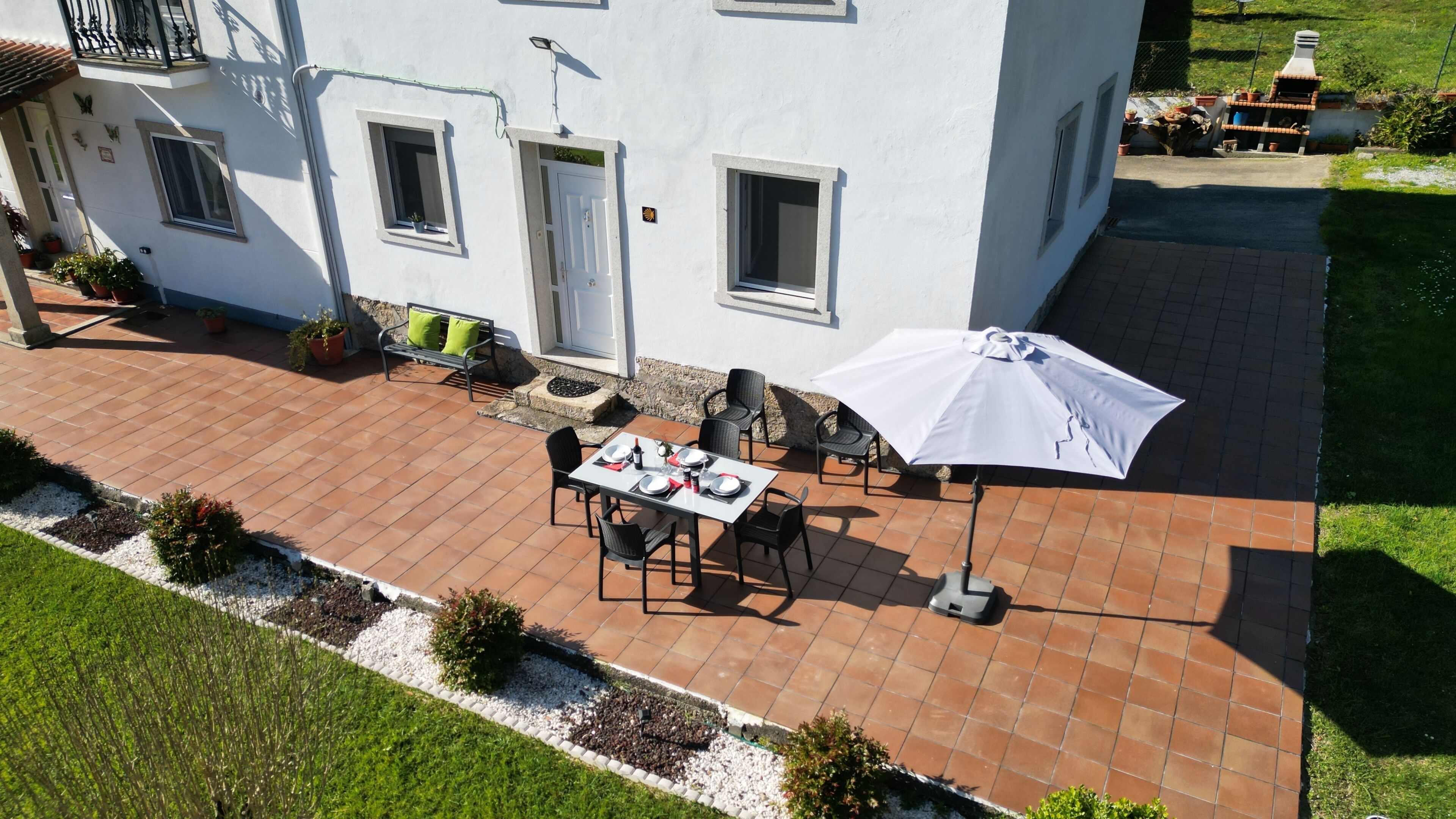 En terrasse med spiseplads, udendørs møbler og grillområde.