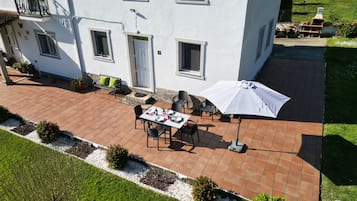 En terrasse med spiseplads, udendørs møbler og grillområde.