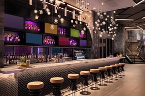A modern bar area with a long counter, multiple stools, and a variety of bottles and glasses on shelves. - Private terrace above the Miami skyline: 1BR corner unit, 25th floor, Downtown Miami (Miami)
