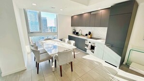 A modern kitchen with a dining area, large windows, and a city view. - Private terrace above the Miami skyline: 1BR corner unit, 25th floor, Downtown Miami (Miami)