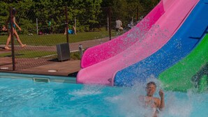Ein Schwimmbecken mit einer bunten Wasserrutsche.
