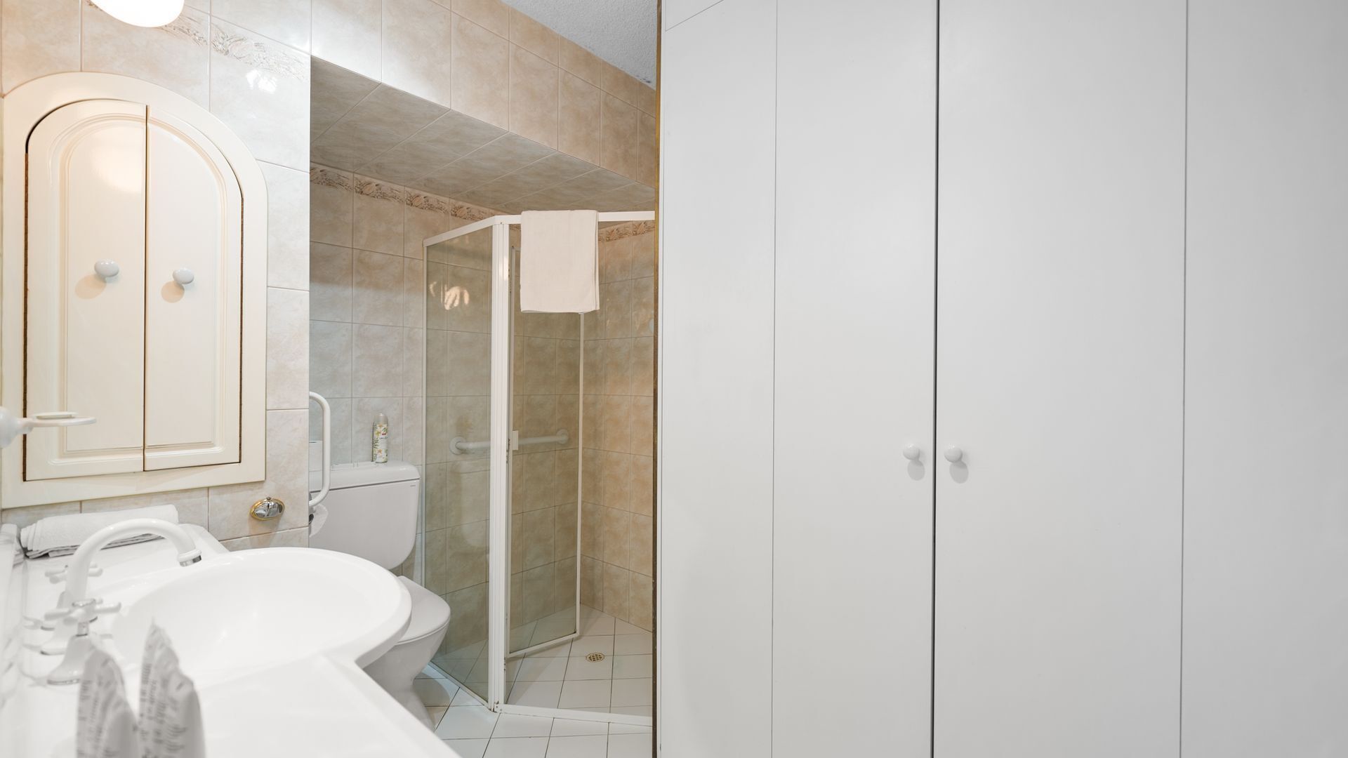 A bathroom with a toilet, sink, and shower.