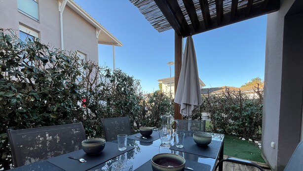 An outdoor dining area with a glass table, chairs, and bowls. - T3 Duplex La Teste, Terrace, Private Parking (La Teste-de-Buch)
