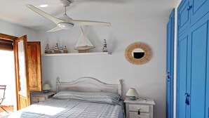 A bedroom with a bed, nightstand, dresser, and wardrobe.