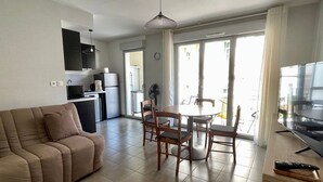 A modern apartment with a living room, dining area, kitchen, and a balcony.