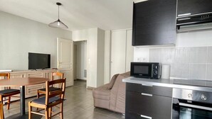 A modern kitchen with a dining area, a microwave, and a built-in oven.