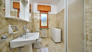 Une salle de bain équipée d’un lavabo, de toilettes et d’un radiateur.