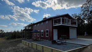 Ein zweistöckiges Gebäude mit roter Fassade und einer überdachten Terrasse.