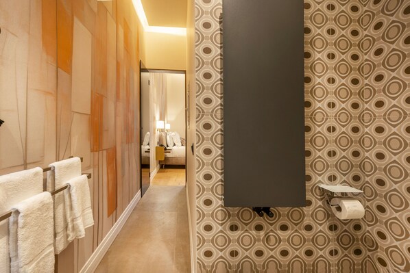 A modern bathroom with a wooden panel wall, a large mirror, and patterned wallpaper.