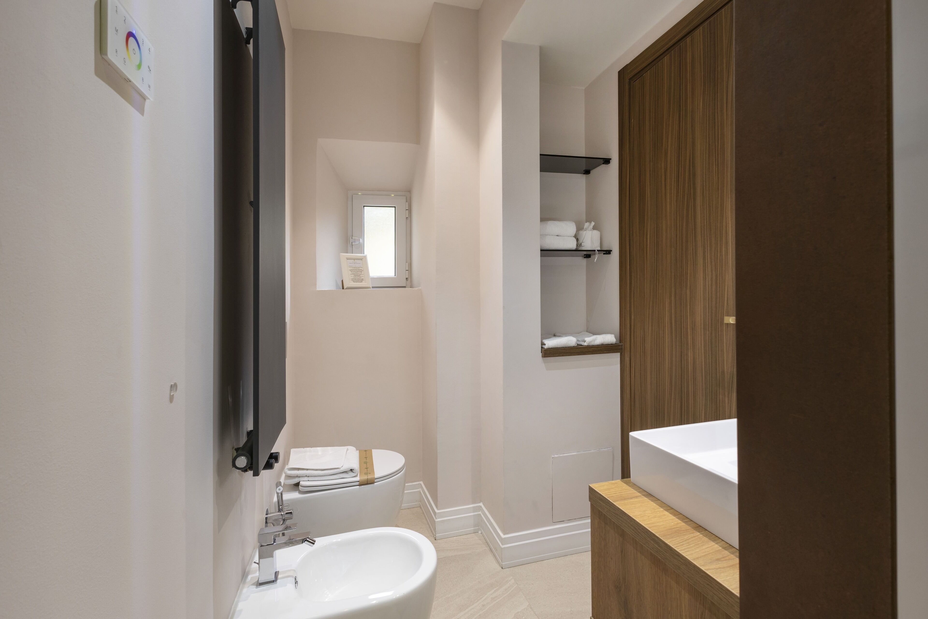 A modern bathroom with a toilet, sink, and mirror.