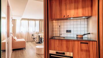 Una cocina moderna con armarios de madera, un fregadero de acero inoxidable y un horno empotrado.