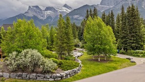 Un jardin aménagé avec un mur de pierres, des arbres et un sentier sinueux.