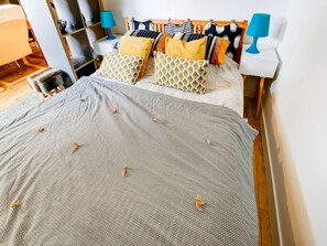 A neatly made bed with a patterned bedspread and pillows, a wooden headboard, and two bedside lamps. - Romantic Stay, Isigny-sur-Mer (Isigny-sur-Mer)