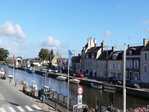A waterfront street with buildings, a canal, and boats. - Romantic Stay, Isigny-sur-Mer (Isigny-sur-Mer)