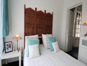 A bedroom with a wooden headboard, a bedside table with a lamp, and a framed picture. - Romantic Stay, Isigny-sur-Mer (Isigny-sur-Mer)