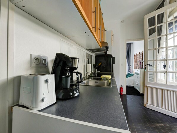 Cocina compacta con tostadora, cafetera y pileta.