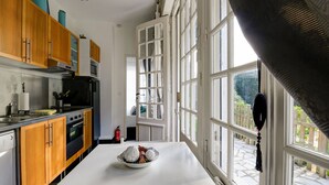A modern kitchen with wooden cabinets, a white countertop, and a large window with a view of the outdoors. - Romantic Stay, Isigny-sur-Mer (Isigny-sur-Mer)