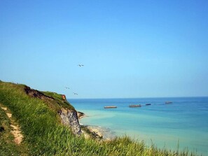 A coastal landscape with a grassy cliff, clear blue sky, and calm sea. - Romantic Stay, Isigny-sur-Mer (Isigny-sur-Mer)