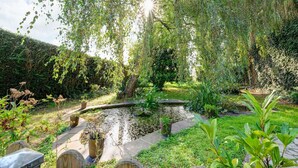 A serene garden with a pond, lush greenery, and a wooden fence. - Romantic Stay, Isigny-sur-Mer (Isigny-sur-Mer)