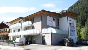 Un hôtel moderne à l’architecture contemporaine, composé de deux étages, doté d’une entrée couverte et offrant une vue sur la montagne.