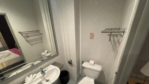 A bathroom with a sink, mirror, toilet, and a towel rack. - Stay At Bedroom (Patong)