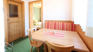 A wooden dining table with chairs, a checkered tablecloth, and a radiator with striped fabric. - Chalet in Austria near Ski Slopes (Mittersill)