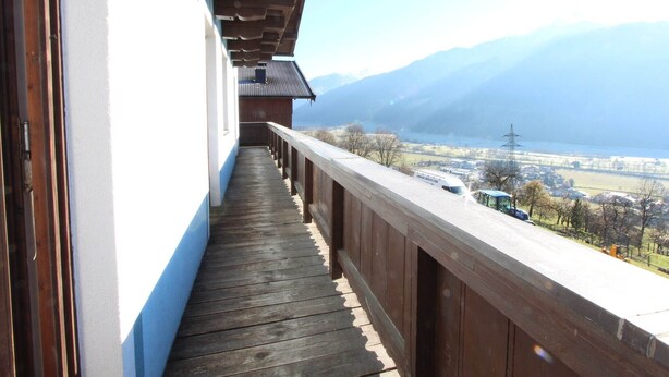 A wooden balcony with a view of a lake and mountains. - Chalet in Austria near Ski Slopes (Mittersill)