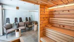 Una habitación moderna con paneles de madera, un separador de vidrio y varias zonas de estar con sillas acolchadas.