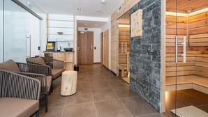 A modern hotel lobby with a reception desk, seating area, and a sauna. - Chalet in Saalbach near Ski Lift (Saalbach-Hinterglemm)