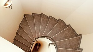 Una escalera en espiral con barandilla y una lámpara sobre ella.
