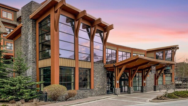 A modern building with large windows and a covered entrance. - Spacious Resort Condo | Near Banff (Canmore)
