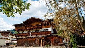 A traditional wooden chalet with multiple balconies, a wooden fence, and a grassy yard. - Apartment in Fügenberg near Ski Lift (Fügenberg)