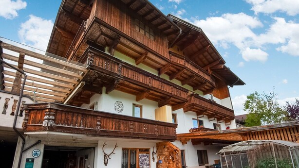 A traditional wooden building with multiple balconies and a clock on the wall. - Apartment in Fügenberg near Ski Lift (Fügenberg)