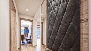 A modern hotel hallway with wooden flooring, a bench, and a tufted headboard. - Farmhouse in Schwendau near Ski Zillertal (Mayrhofen - Schwendau)
