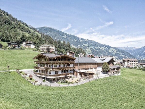 A traditional Alpine-style hotel with multiple floors, balconies, and a central courtyard.