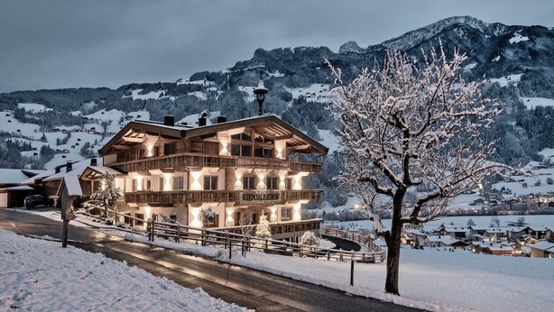A multi-story wooden building with balconies, surrounded by snow-covered landscape and mountains. - Farmhouse in Schwendau near Ski Zillertal (Mayrhofen - Schwendau)