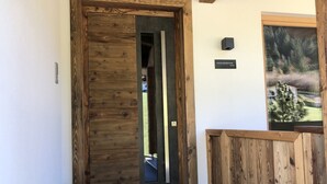 A wooden door with a black frame, a small sign above it, and a framed picture on the wall to the right. - Farmhouse in Schwendau near Ski Zillertal (Mayrhofen - Schwendau)