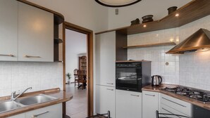 Una cocina moderna con armarios blancos, encimera de madera y cocina a gas.