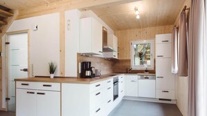 Una cocina moderna con armarios blancos, una isla central y un horno empotrado.