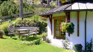 A rustic chalet with a wooden bench and flower boxes. - Apartment in Nassfeld (Nassfeld)