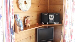 A wooden room with a TV, speakers, and a decorative wreath. - Apartment in Nassfeld (Nassfeld)