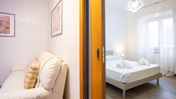 A hotel room with a bed, a sofa, and a wooden door. - La Casa di Daeny in Naples (Naples)