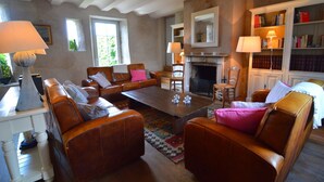 A cozy living room with leather sofas, a coffee table, and a fireplace. There are bookshelves and a lamp in the room. - Elegant Estate Stay, Maredsous (Maredsous)