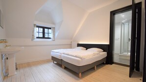 A bedroom with a bed, a window, a sink, and a door leading to a bathroom. - Spa Grand Wellness Villa (Spa)