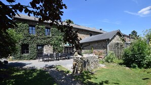 A stone building with a covered outdoor seating area and a stone wall. - Gouvy Forest Farmhouse (Gouvy)