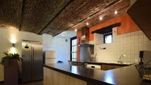A modern kitchen with a central island, stainless steel appliances, and a brick ceiling. - Gouvy Forest Farmhouse (Gouvy)