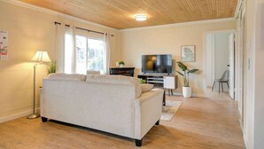 A living room with a sofa, TV, and a plant.