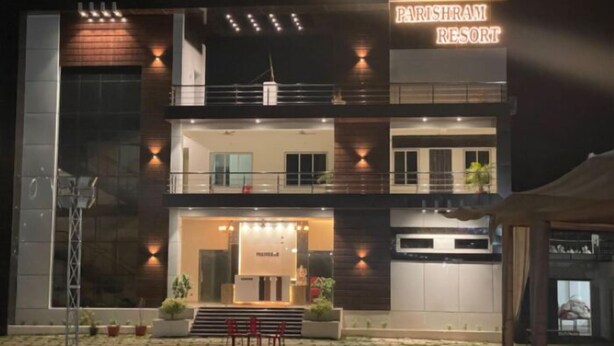 Un edificio de dos pisos con un cartel que dice "Parishram Resort".