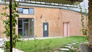 A brick building with a covered patio, a door, and a window. - Farmhouse Retreat, Fernelmont (Forville)